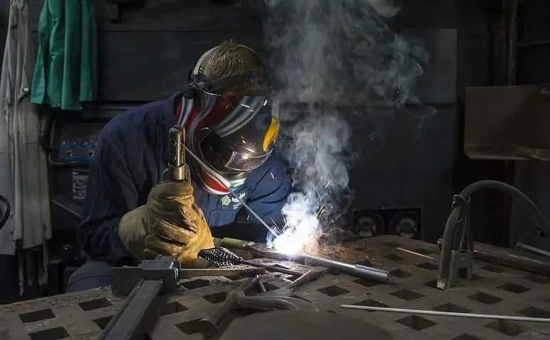 man welding metal alloy